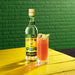 A bottle of Wray & Nephew Overproof Rum and a glass of rum punch cocktail.
